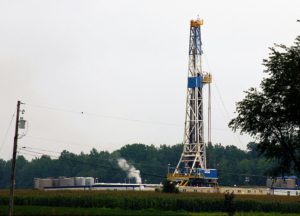 A shale oil drilling rig standing tall in a rural field